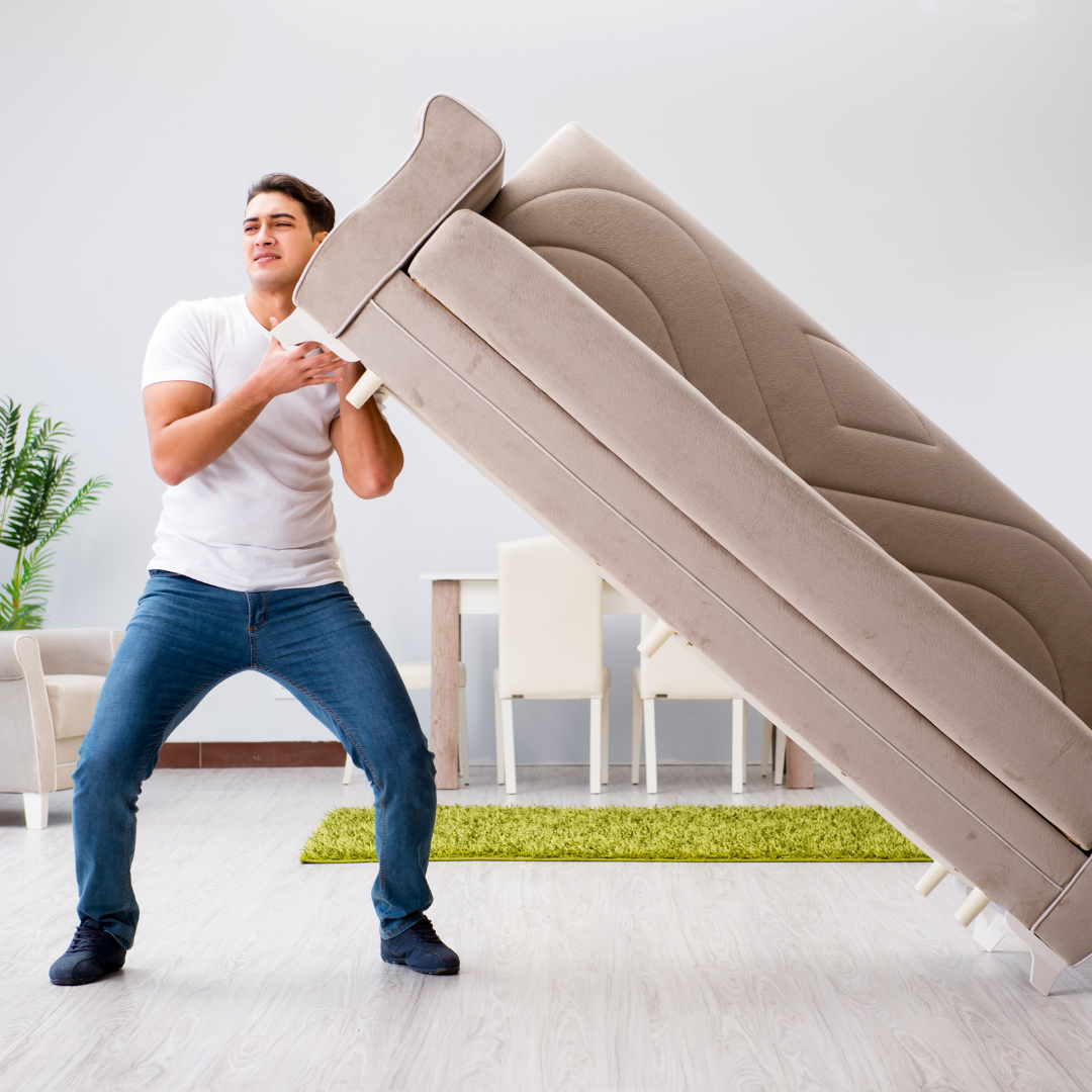 man lifting a sofa with his left shoulder
