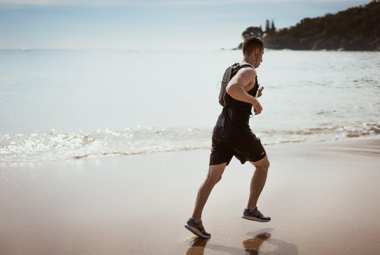 Runner on the beach illustrating sore arches when running on uneven sand surfaces