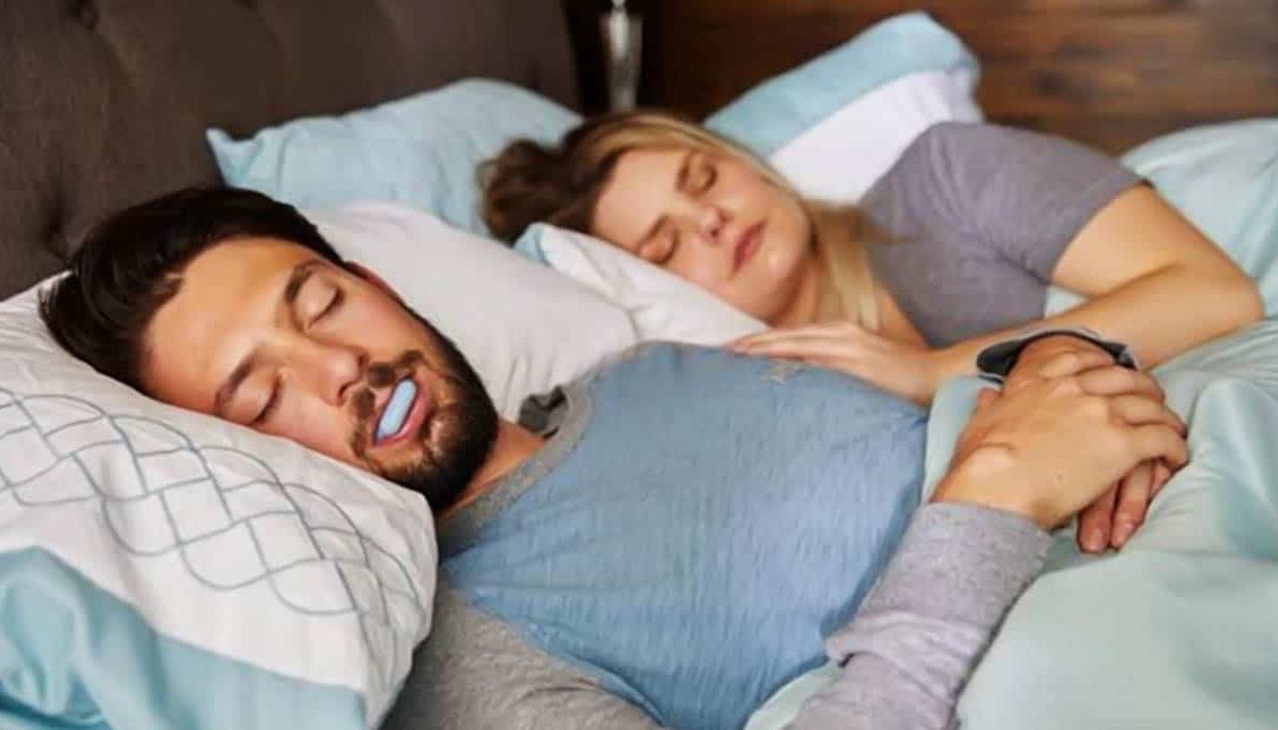 Snorkeskinne: Liten Skinne, Stor Effekt på Søvnen 20 Mann sover med munnskinne i munnen, mens kvinne sover rolig ved siden av ham i en dobbeltseng.