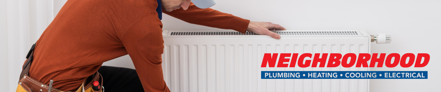 A service professional inspecting boiler heating system and boiler vs furnace options.