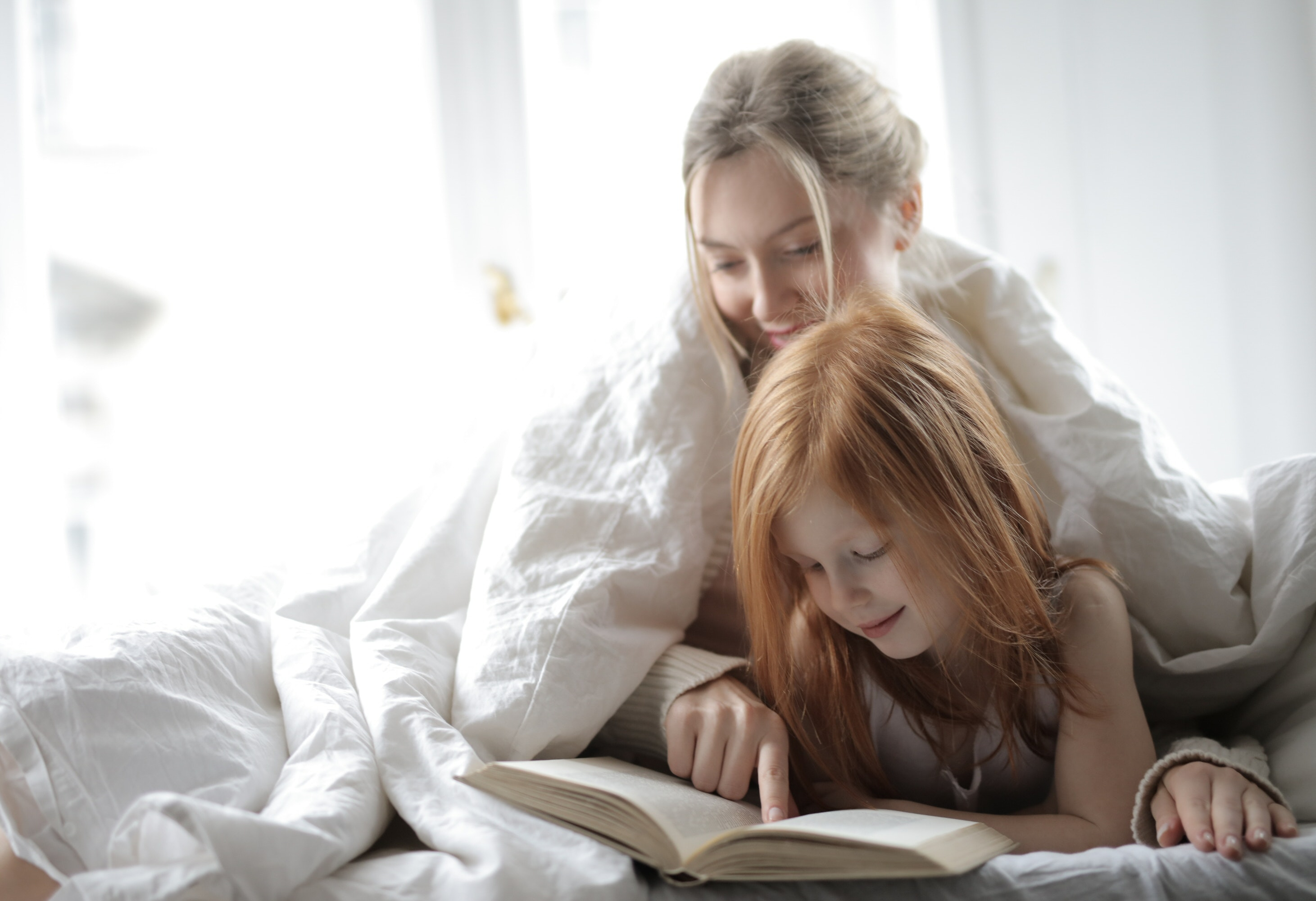 Daughter and Mother Reading Stories on the Bed