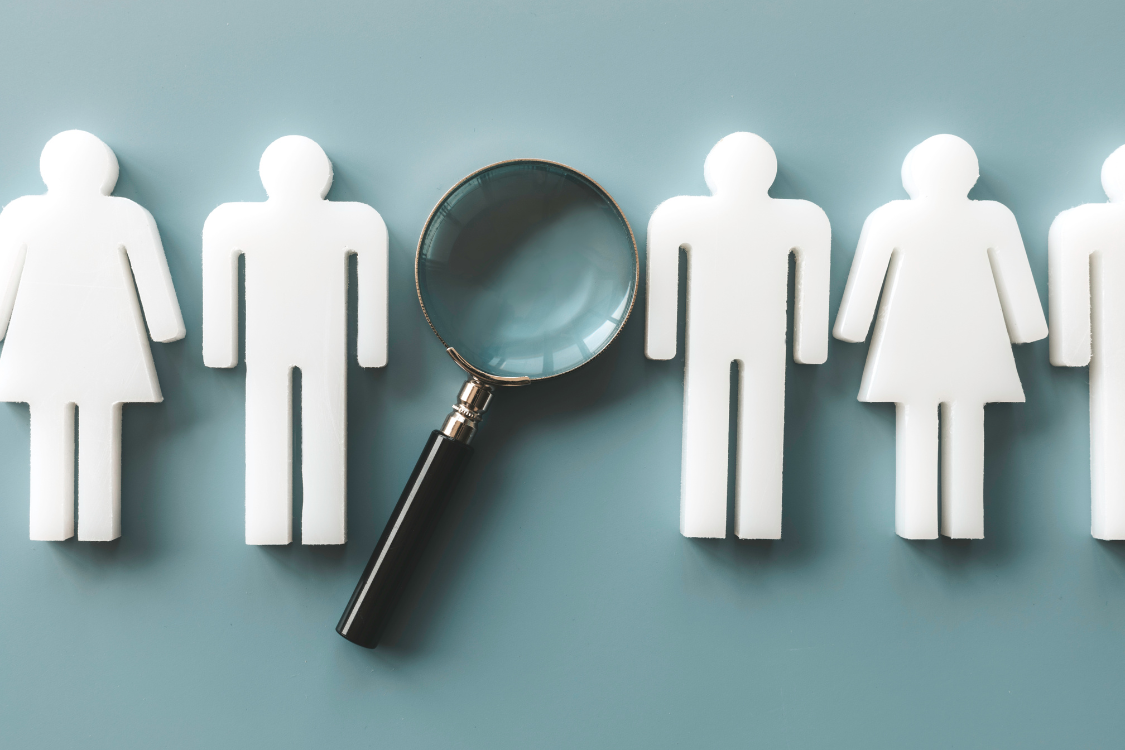 Magnifying glass over candidate icons representing virtual hiring and talent screening