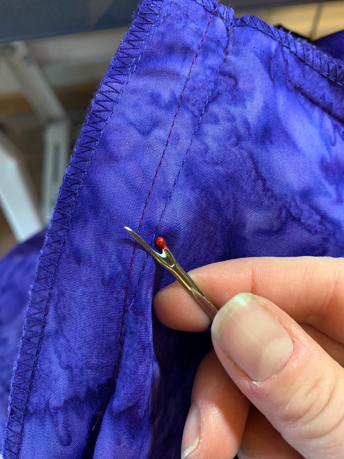 close up image of alterations being done by a seamstress or tailor at a dressmaker shop using tools and patterns