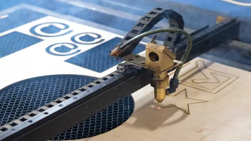 A laser machine cutting stencils on a cardboard.