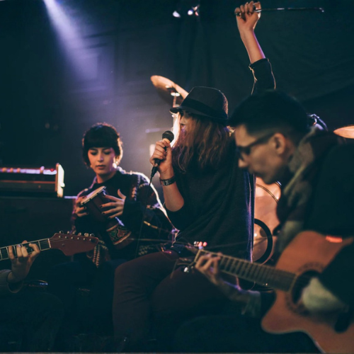 **Musicians performing in a live music venue, illustrating prolonged exposure to high sound levels and the hearing risks faced by performers and entertainment industry workers