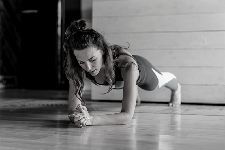 Woman doing a plank in a bare room