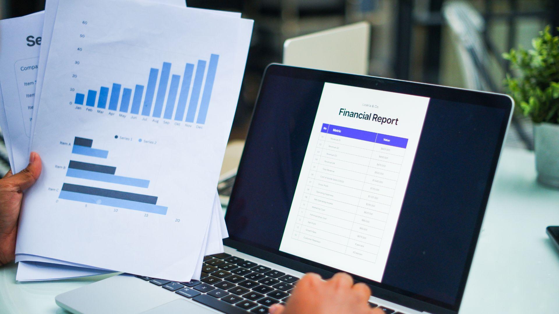 Financial reports and charts displayed on laptop and documents showing balance sheet data used by a property manager to prepare a good owner statement including legal fees.