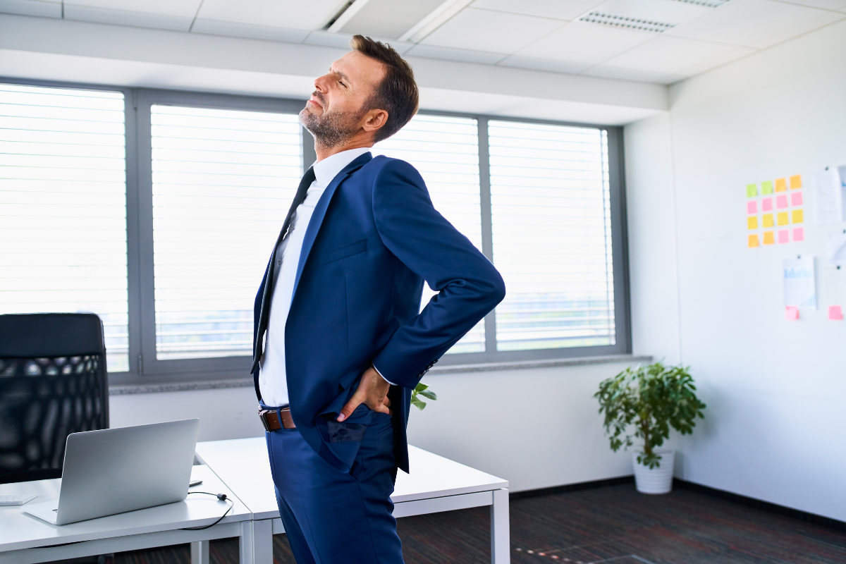 Worker stretching due to a sore back from sitting to much with no movement.