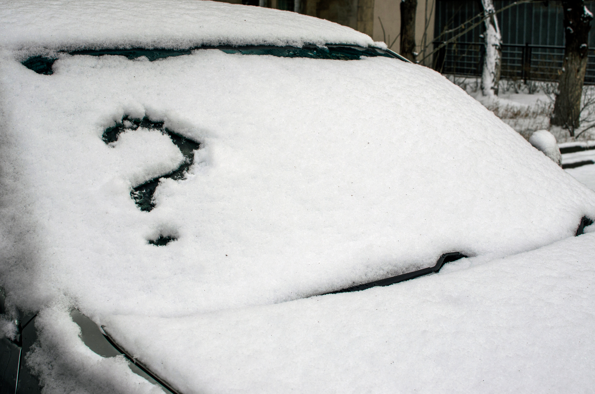 Question mark on a windshield covered with snow