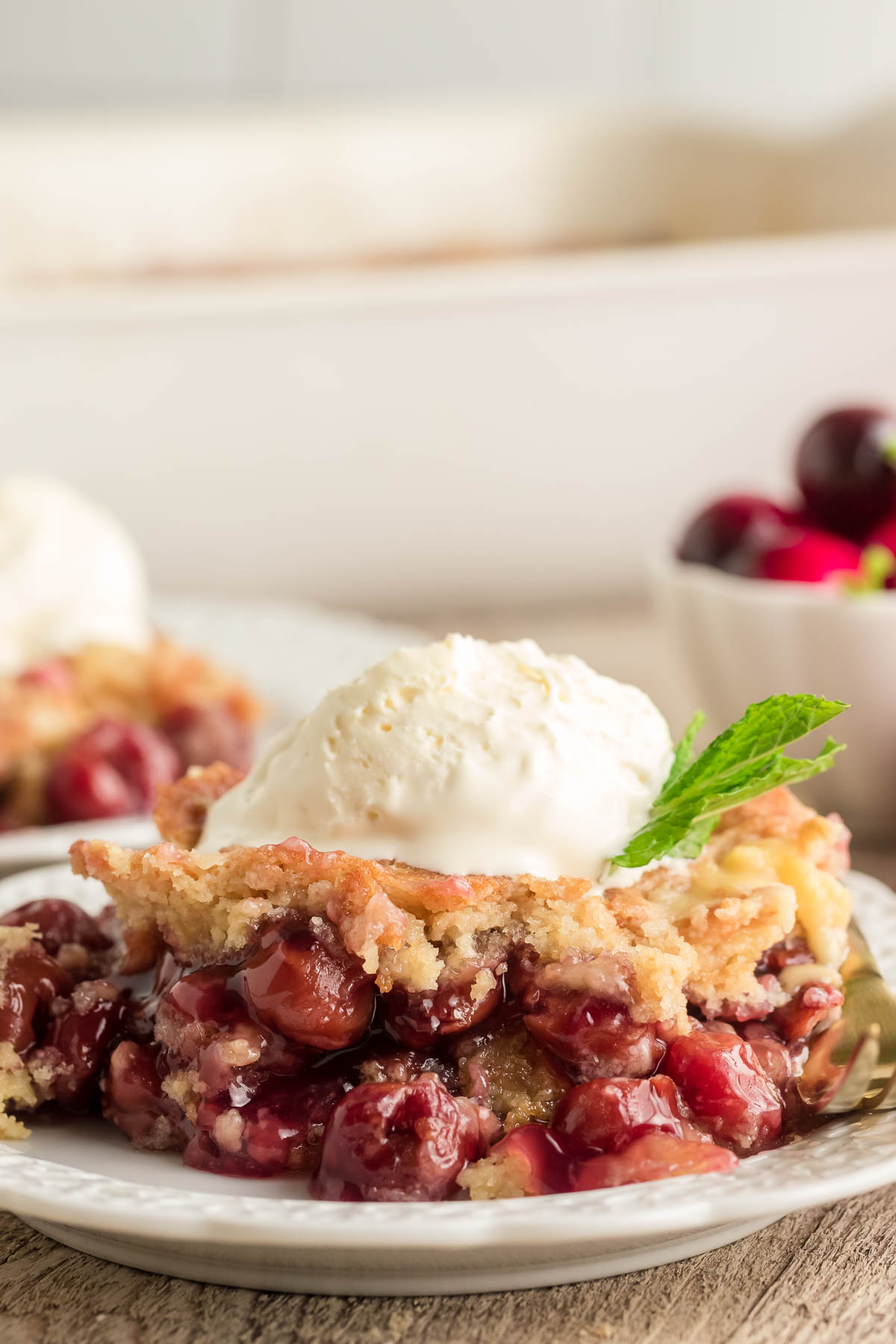 Cherry dump cake on a plate topped with icecream