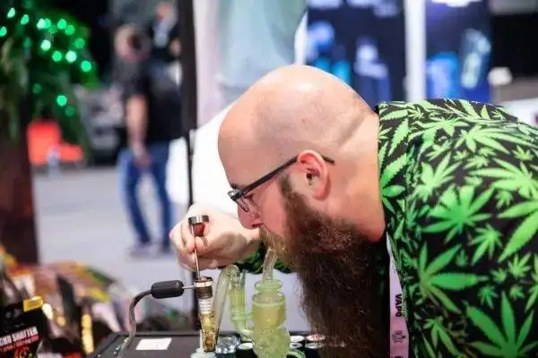  Steve, from Steve's Goods, demonstrates the use of a dab rig for consuming CBD dabs at an event where CBD is legally permitted