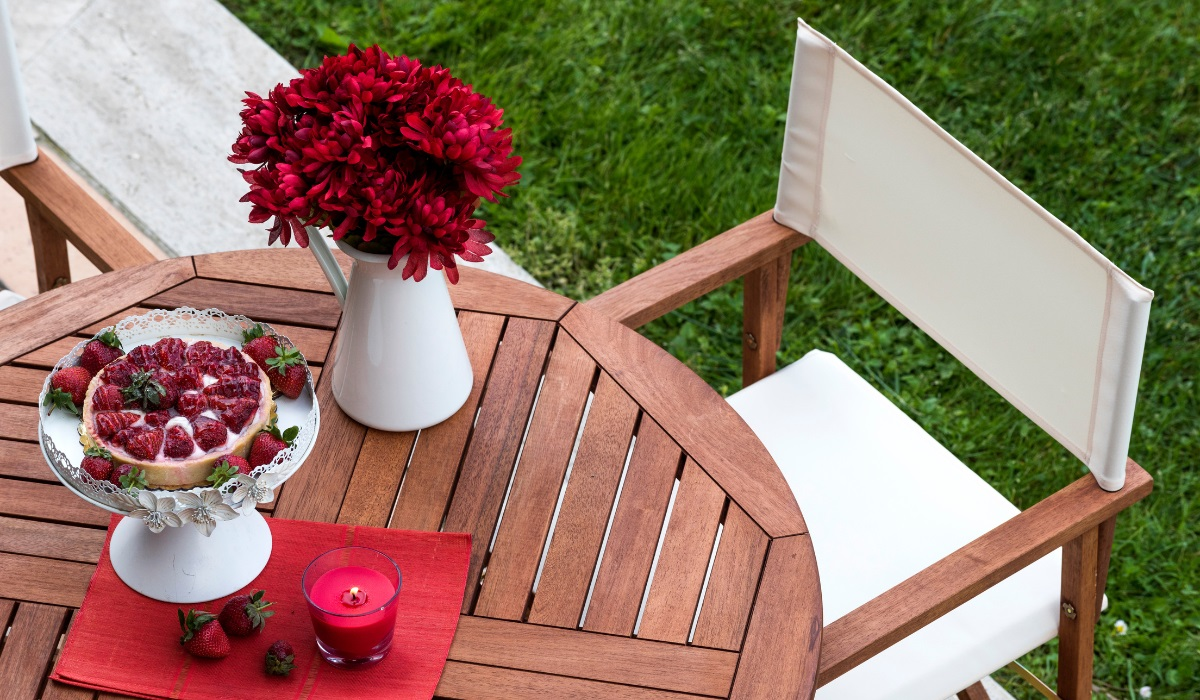 Restore wooden garden furniture - neat garden table and chair - with strawberries and red flowers