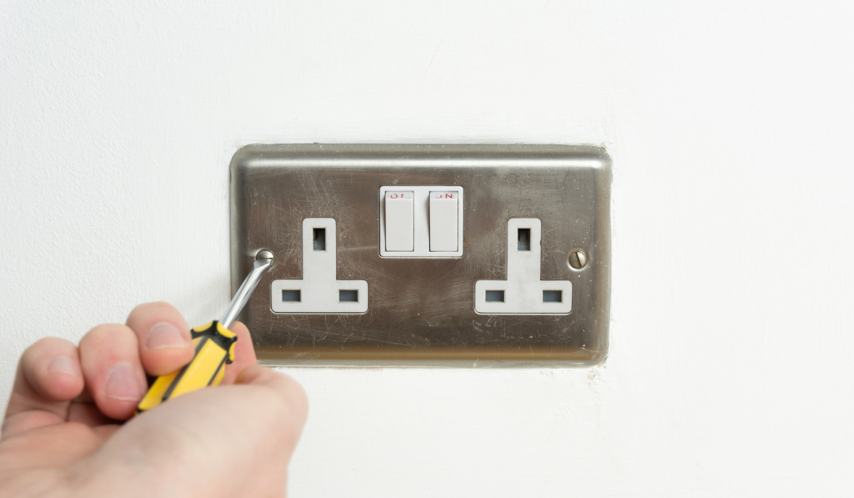 Plug socket being unscrewed - metallic finish 