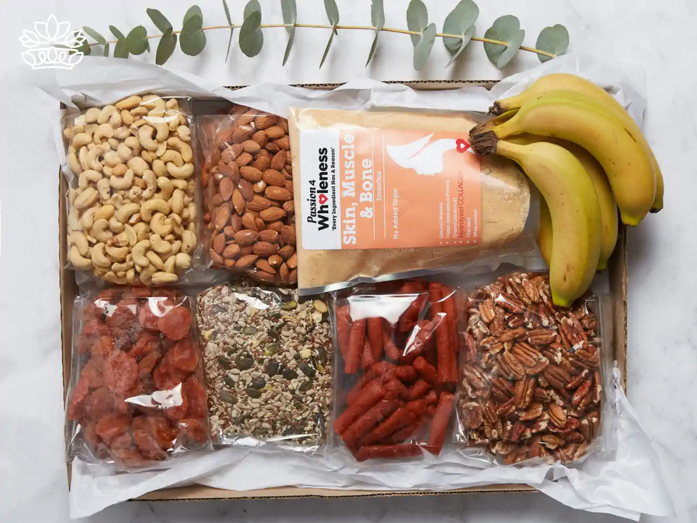Assortment of healthy snacks including cashews, almonds, dried strawberries, seed mix, pecans, and bananas, neatly packaged in a box, from the mental health gift boxes by Fabulous Flowers and Gifts. Thoughtfully curated to enhance well-being and delivered with care.