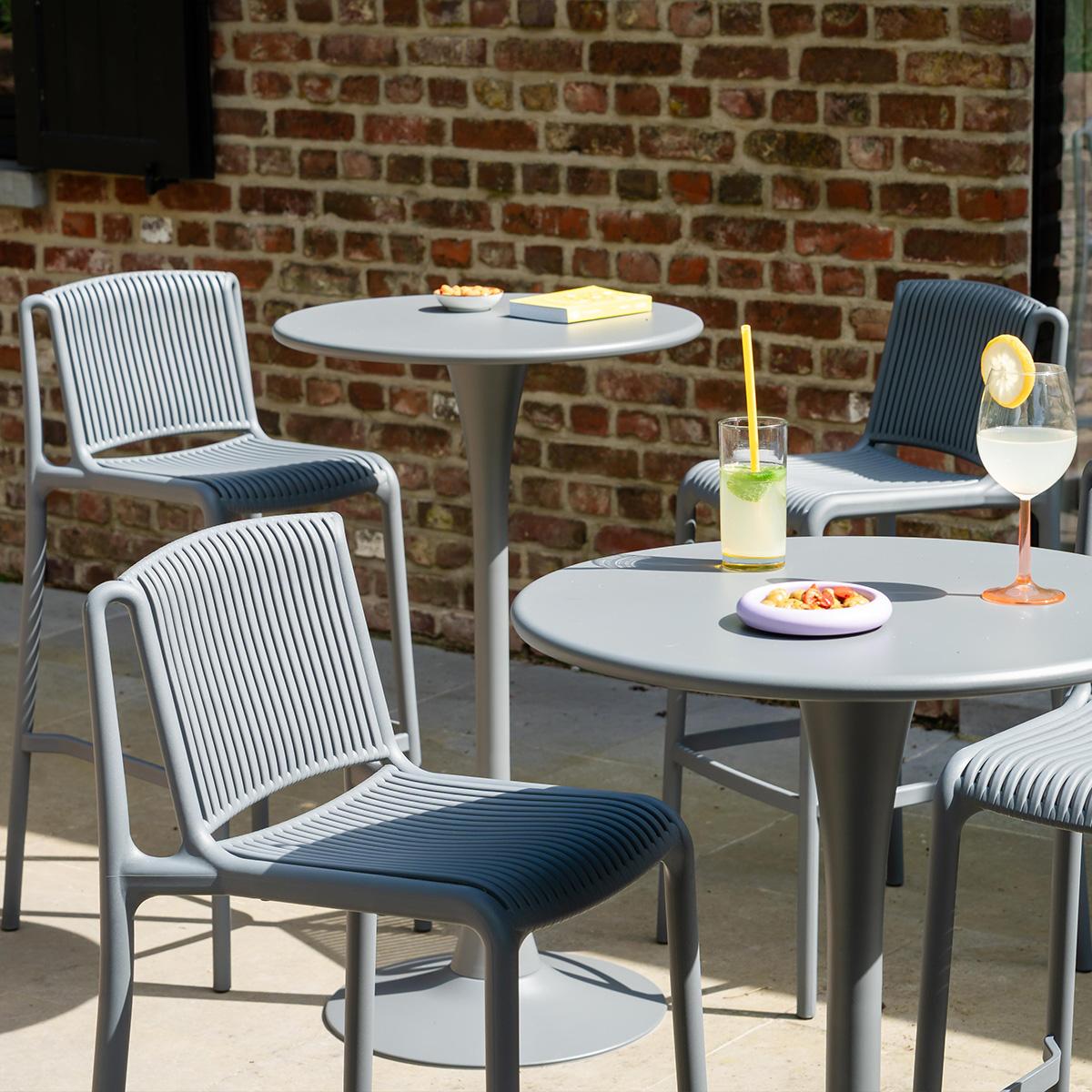 Salon de jardin en résine Andrea installé sur une terrasse extérieure de café avec ambiance apéro conviviale et mobilier lounge confortable