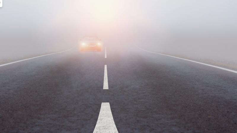 A car driving in visibility less than 100 meters with its fog lights on