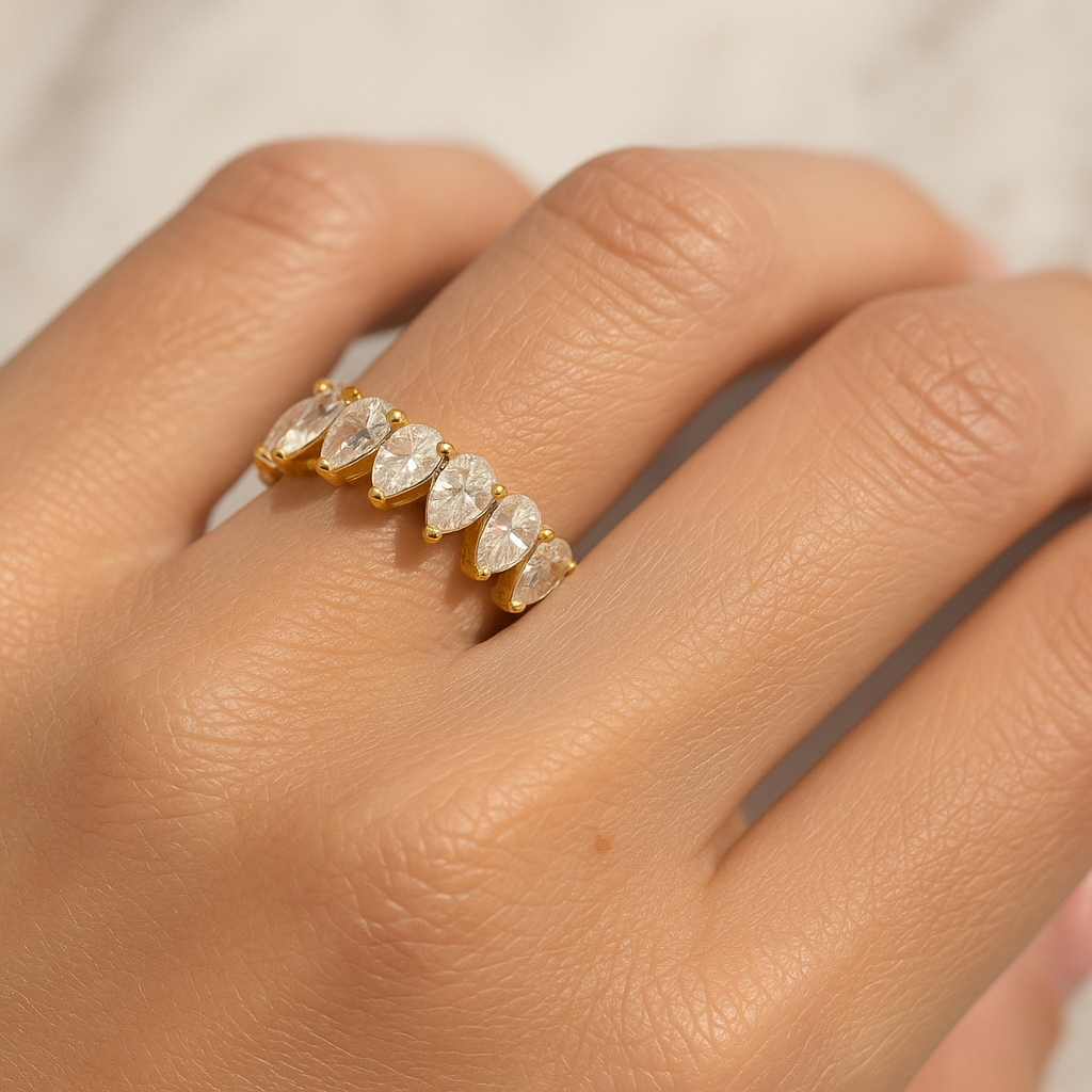 Stilingos moters ranka su baltame auksiniame žiede inkrustuota deimantine juostele su ovalo formos deimantais ratu