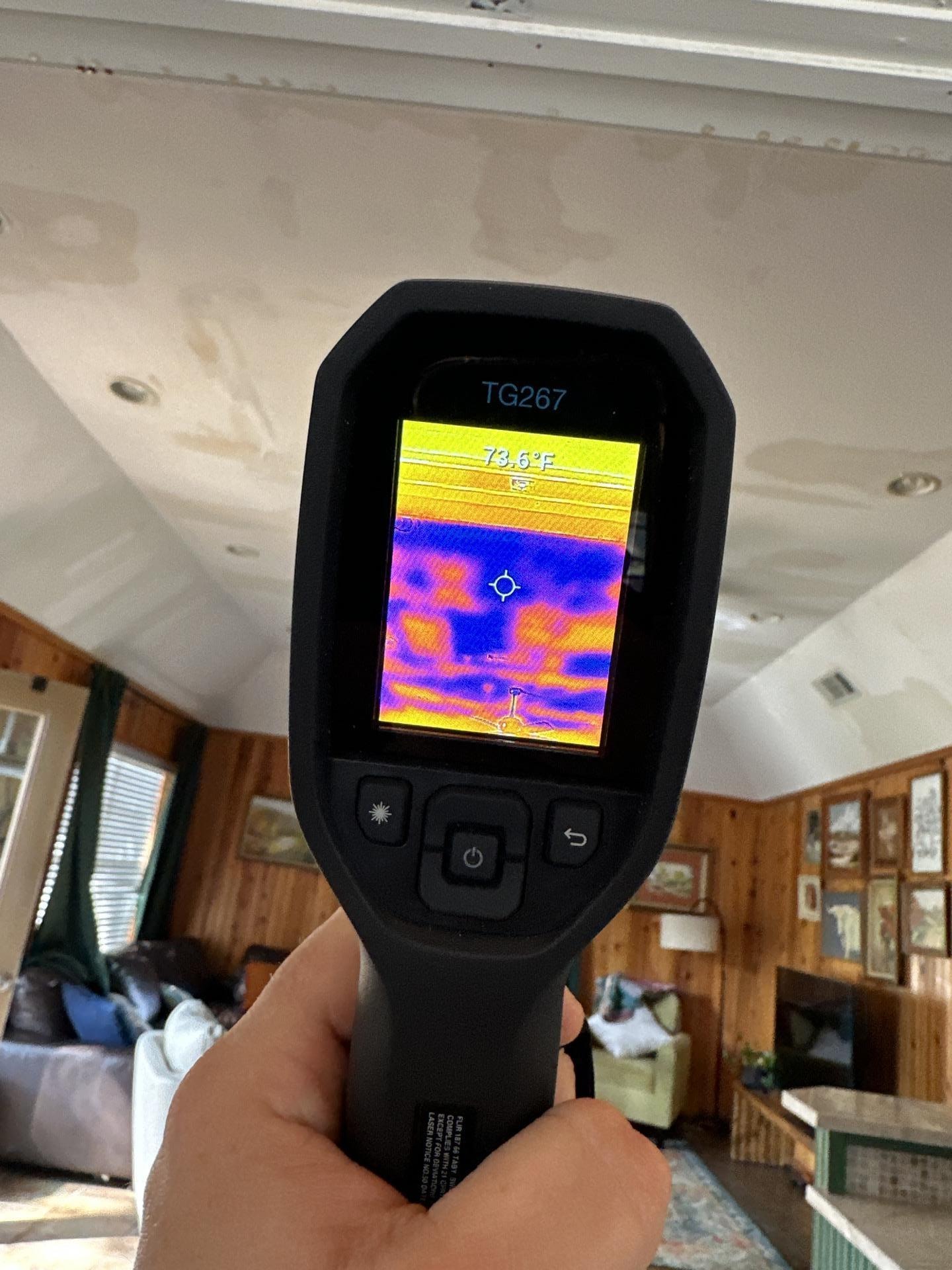 A technician is using an infrared thermal imaging camera to identify hidden moisture pockets within walls, which is crucial for preventing mold growth and further damage during the water extraction and remediation process. This inspection helps ensure the structural integrity of the property and aids in effective water damage restoration.