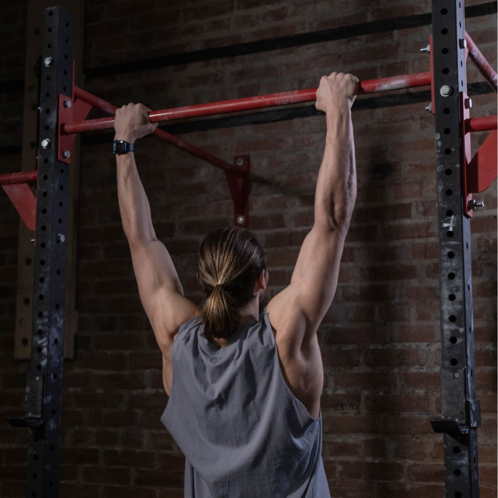 A person using chalk to improve grip on a pull up bar