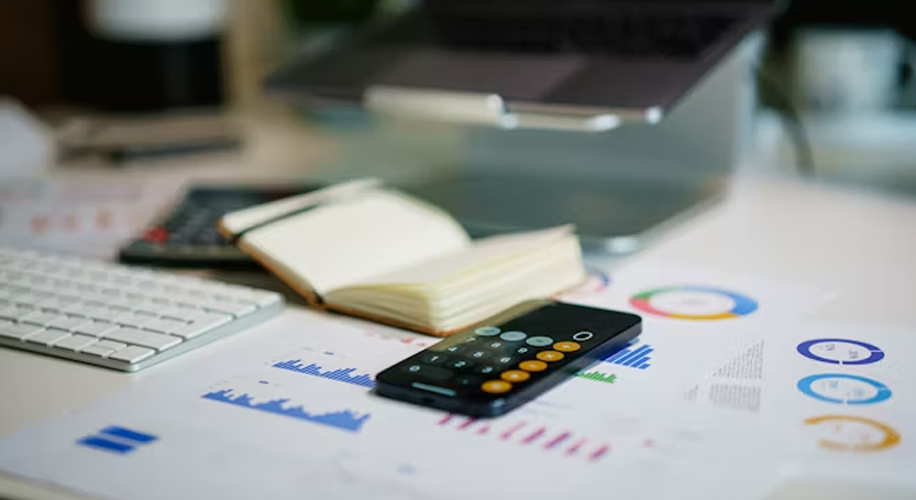 Career Growth with Amis: A 3–5 Year Journey Looks Like With Us 6 Financial charts, a calculator app, and an open notebook on a desk, representing corporate accounting and strategic career planning