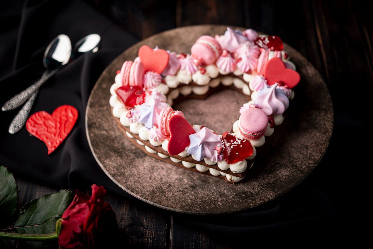 Easy to make heart shaped cake topped with cookies, candies with colors of red and pink