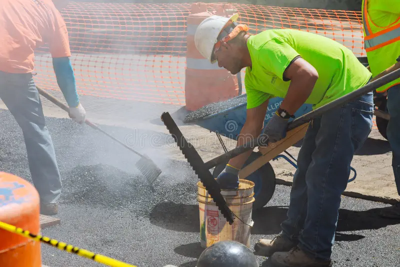 A picture of asphalt binder being poured on a pavement