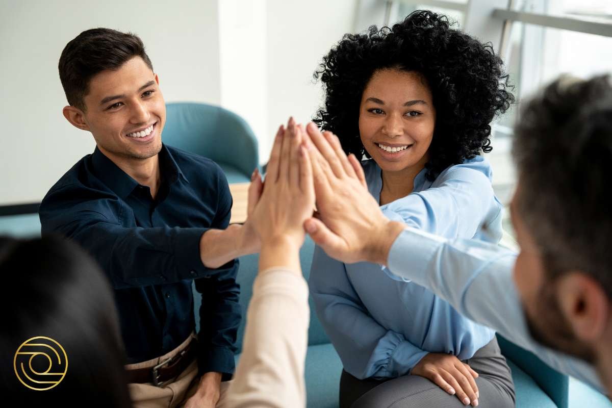 Professional team celebrating a successful milestone with a group high-five – Increase My Impact Through Others and Strategically