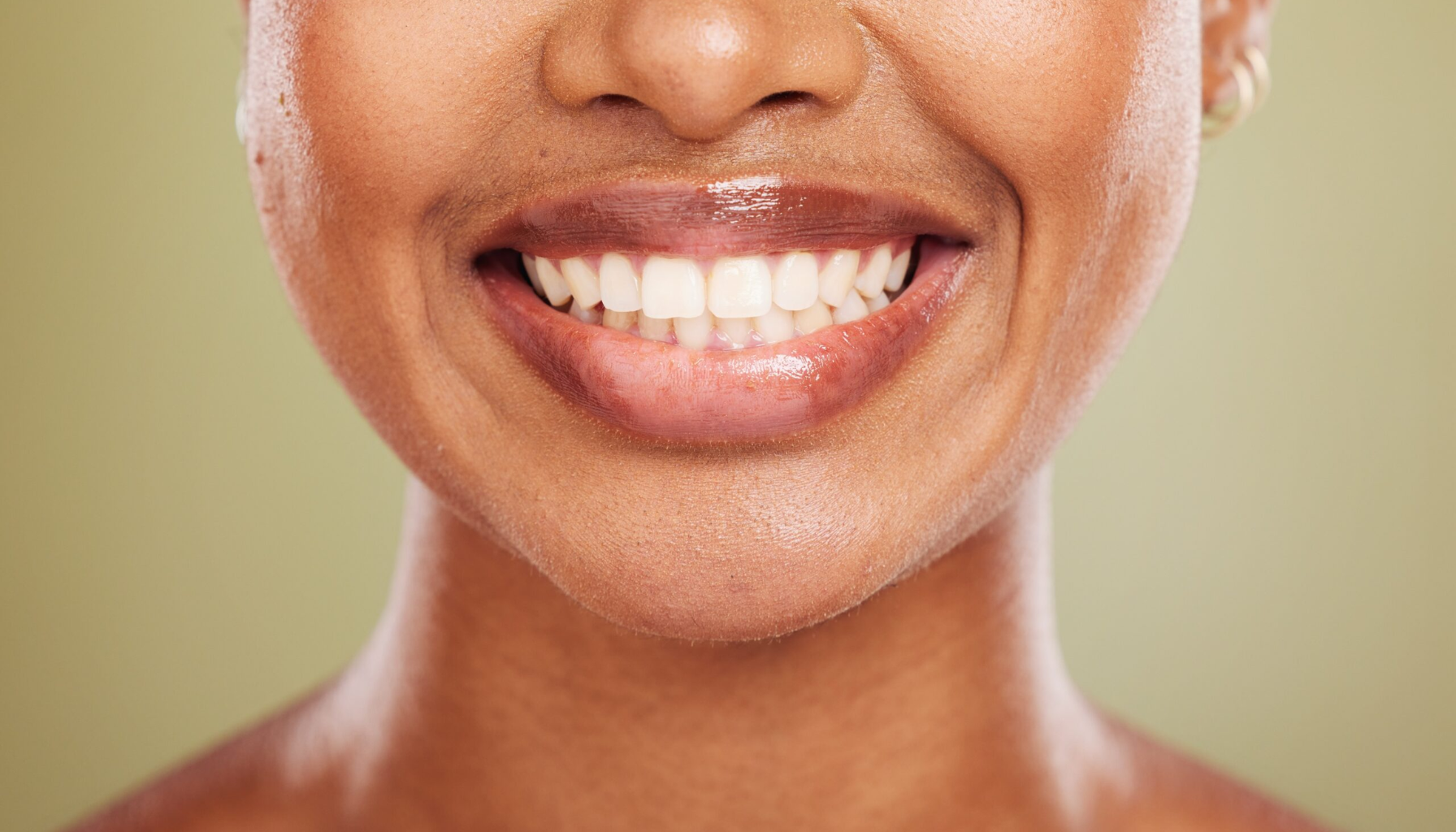 Tann: Mer Enn Bare Emalje – Bygget for Hele Livet 15 Nærbilde av smilende person med sunne hvite tenner, naturlige lepper og jevn hudtone mot rolig bakgrunn.