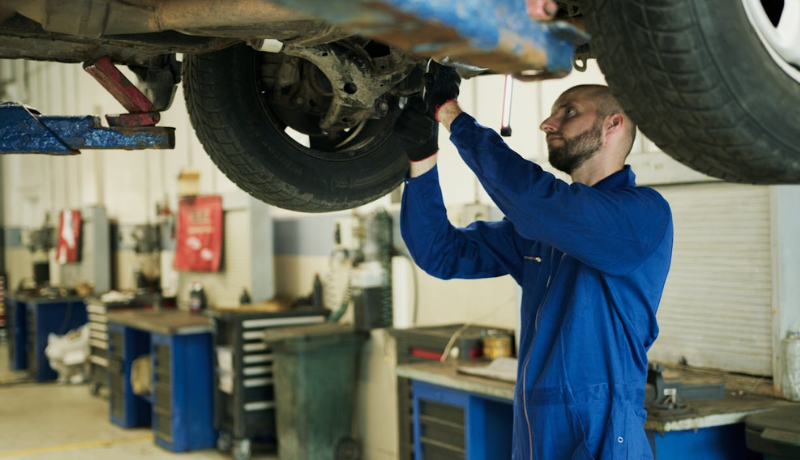 A professional is doing car underbody coating