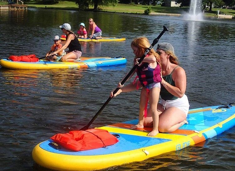 kids practice on a stand up paddle board