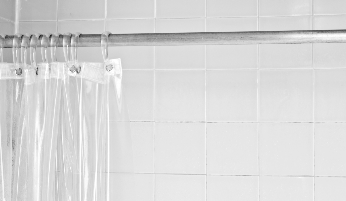 Traditional chrome curtain rod - transparent PVC shower curtain - white tiled shower