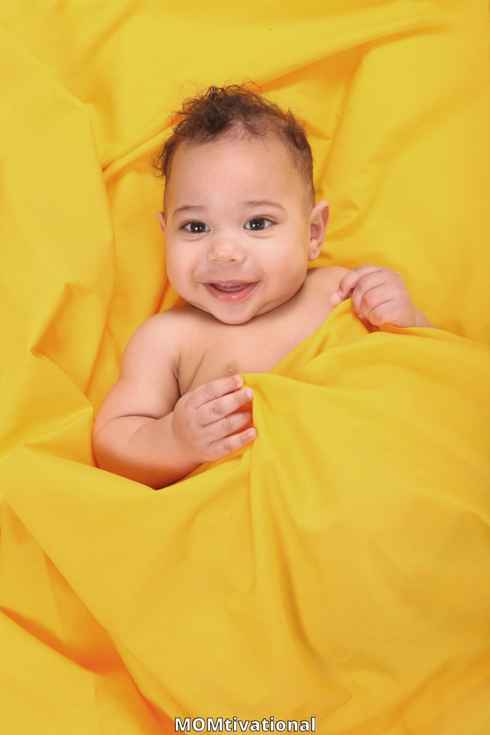 Little boy in a sheet of yellow smilng
