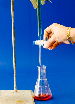A laboratory reaction with a burette used to deliver a precise amount of liquid