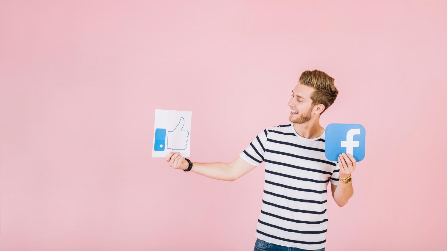 Man holding Facebook logo and like button logo on a piece of paper.