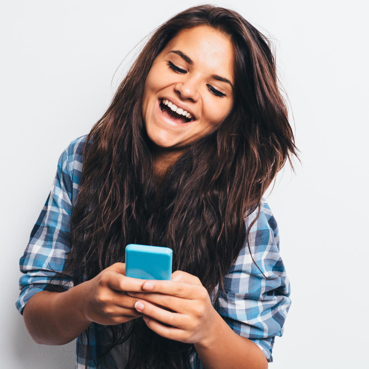 Girl laughing while texting - Featured In: Signs A Girl Likes You Over Text