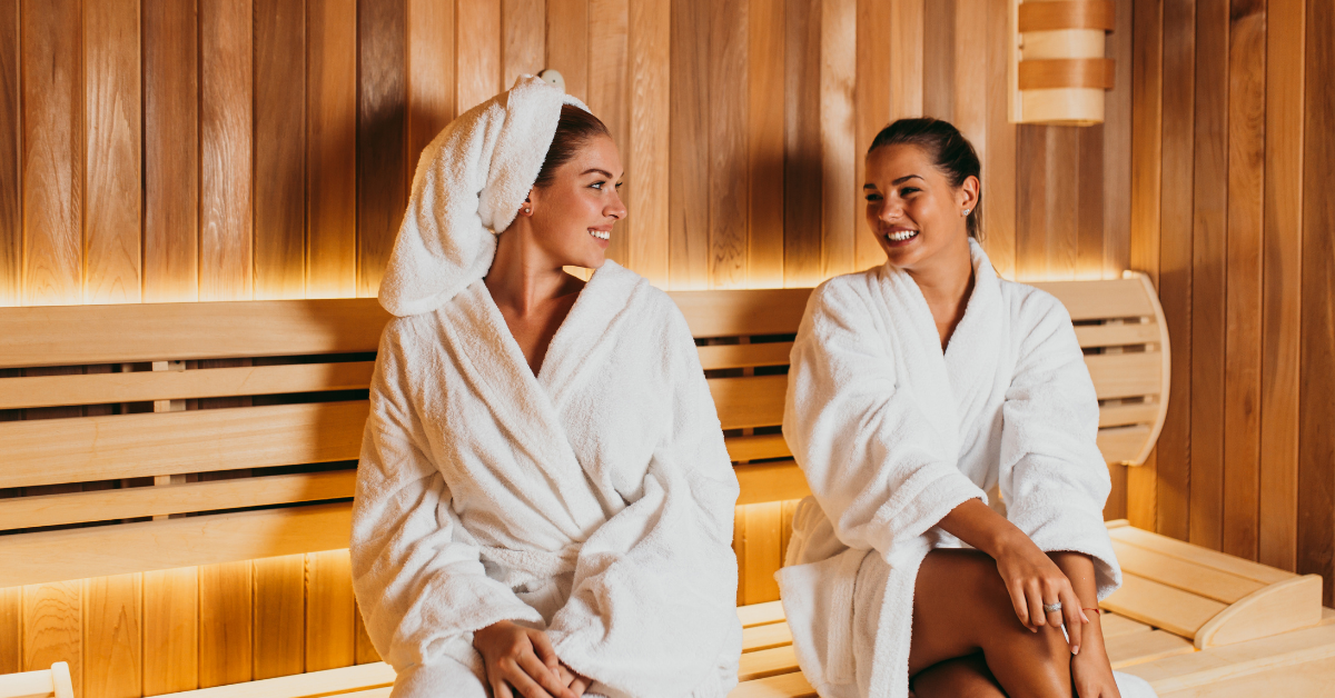 Two people enjoying the health benefits of a sauna session for physical and mental health.