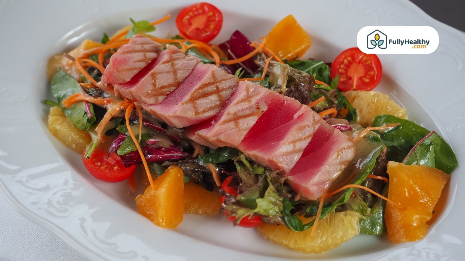 Sliced grilled tuna on mixed salad with citrus and vegetables