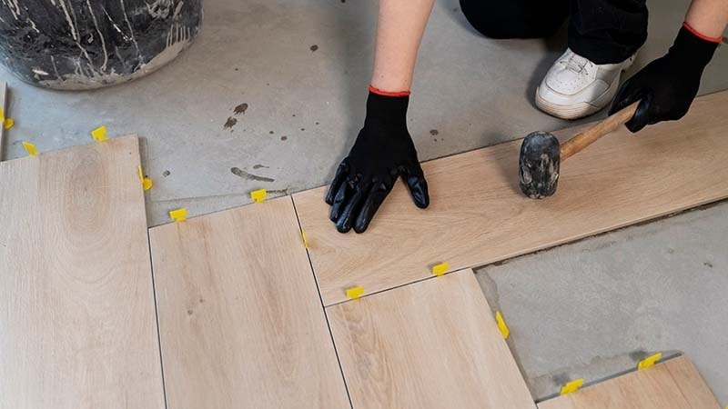 A person installing vinyl floor tiles