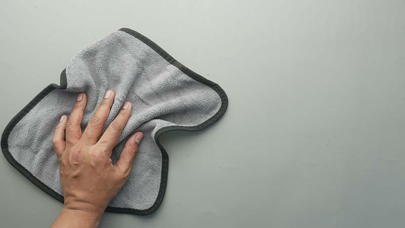 Grey microfiber towel with piped edges on grey table