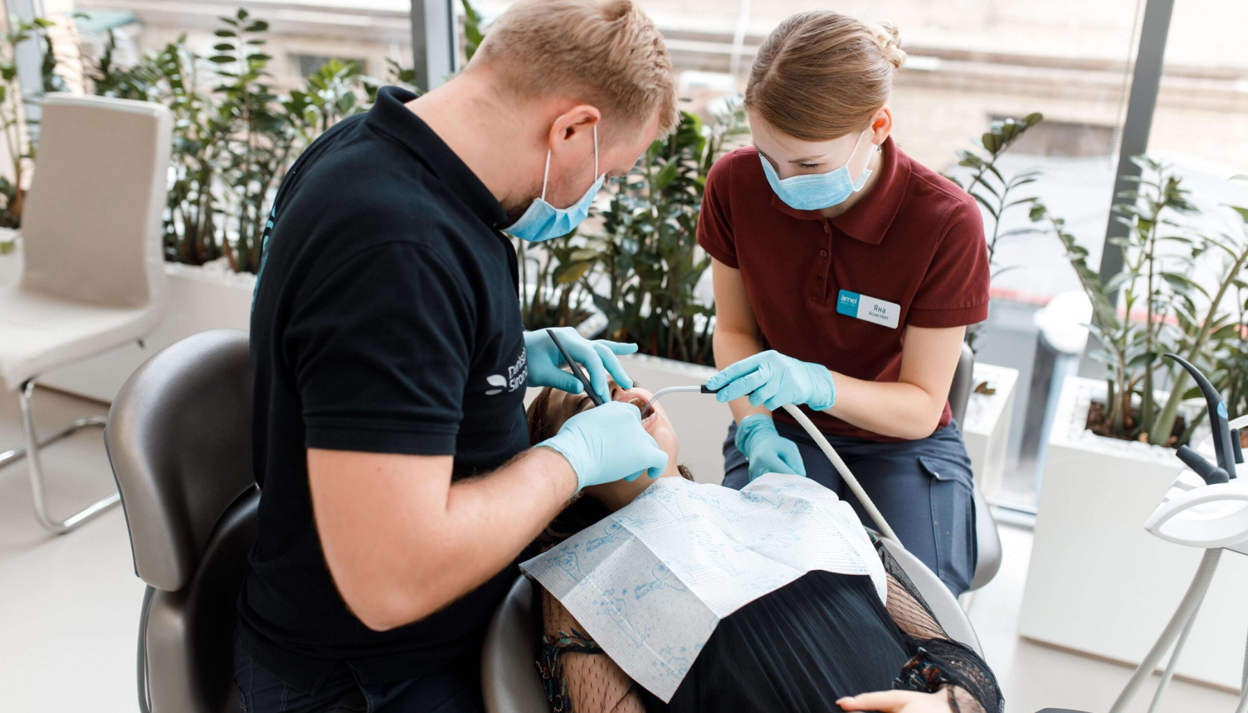 Pulpitt: Når Tannverken Betyr Alvor – Dette Må Du Vite 18 Tannlege og assistent utfører behandling på pasient som ligger i tannlegestol, begge iført munnbind og hansker.