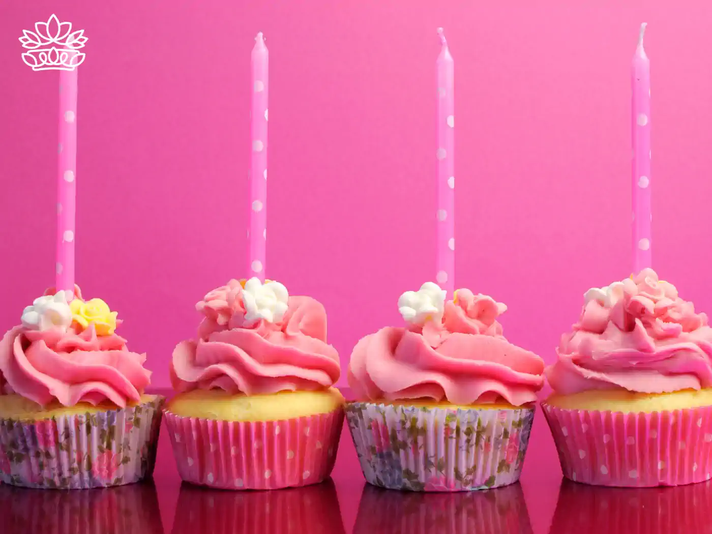 Four delicious cupcakes with pink frosting and candles, perfect for celebrations. Fabulous Flowers and Gifts