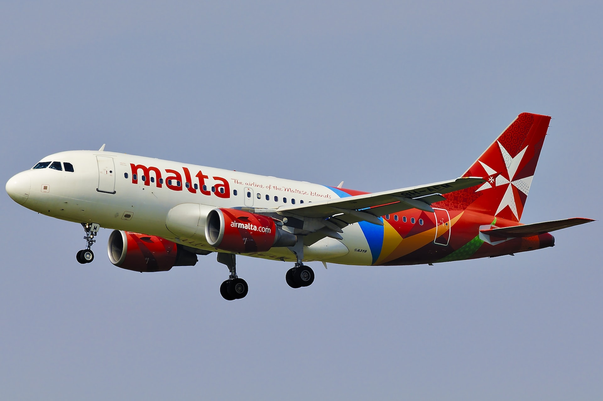 Malta Airlines aircraft landing on a clear day.