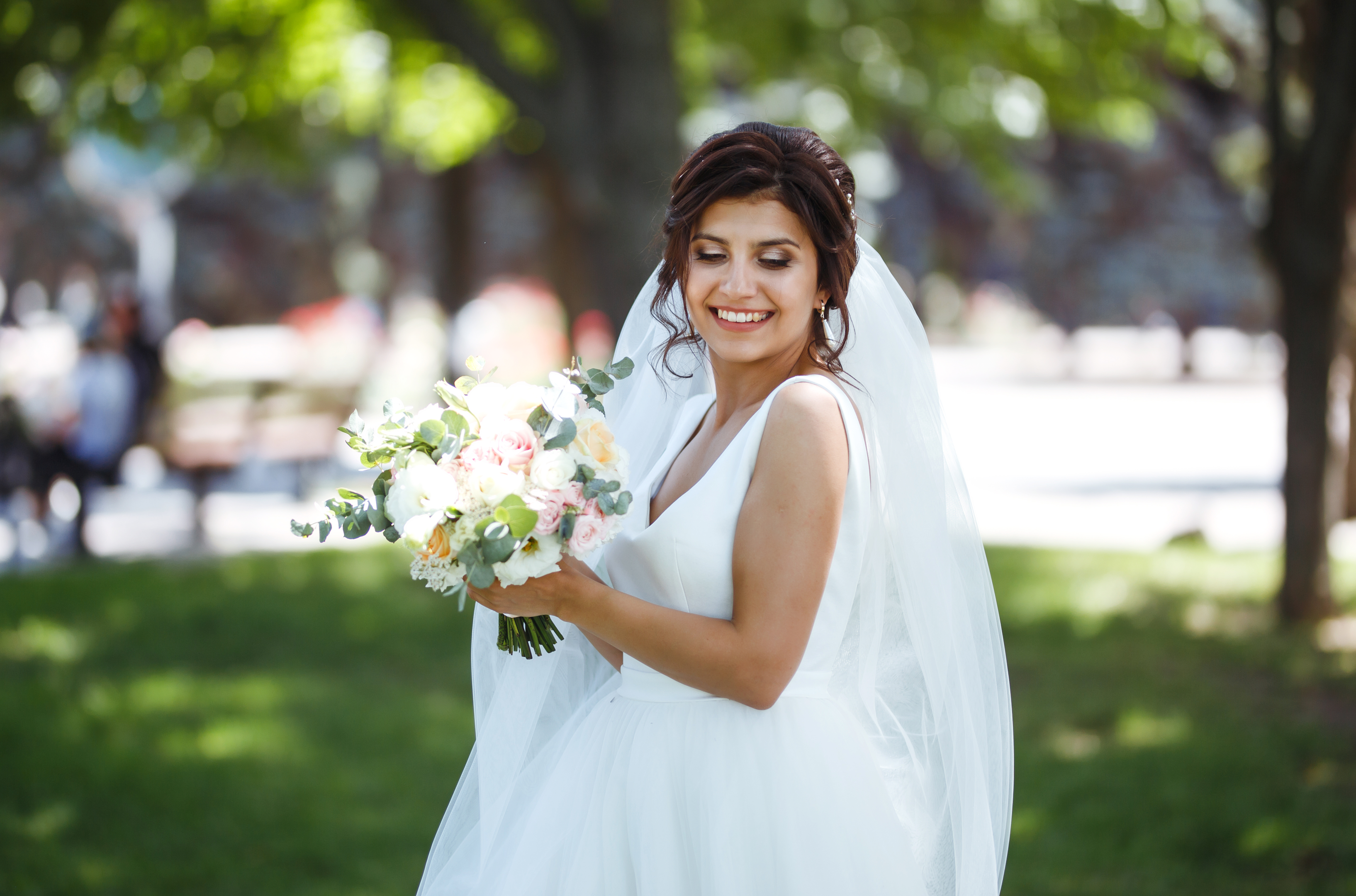 "Bride in white, strolling in the park, symbolizing the unity and interdependence of marriage."