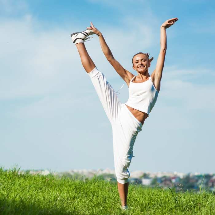 Woman stretching with a joyful expression during a fitness session after taking Vtamin B12.