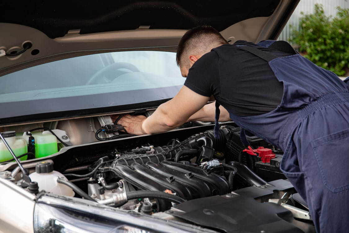 A mechanic checking the transmission fluid level of a car