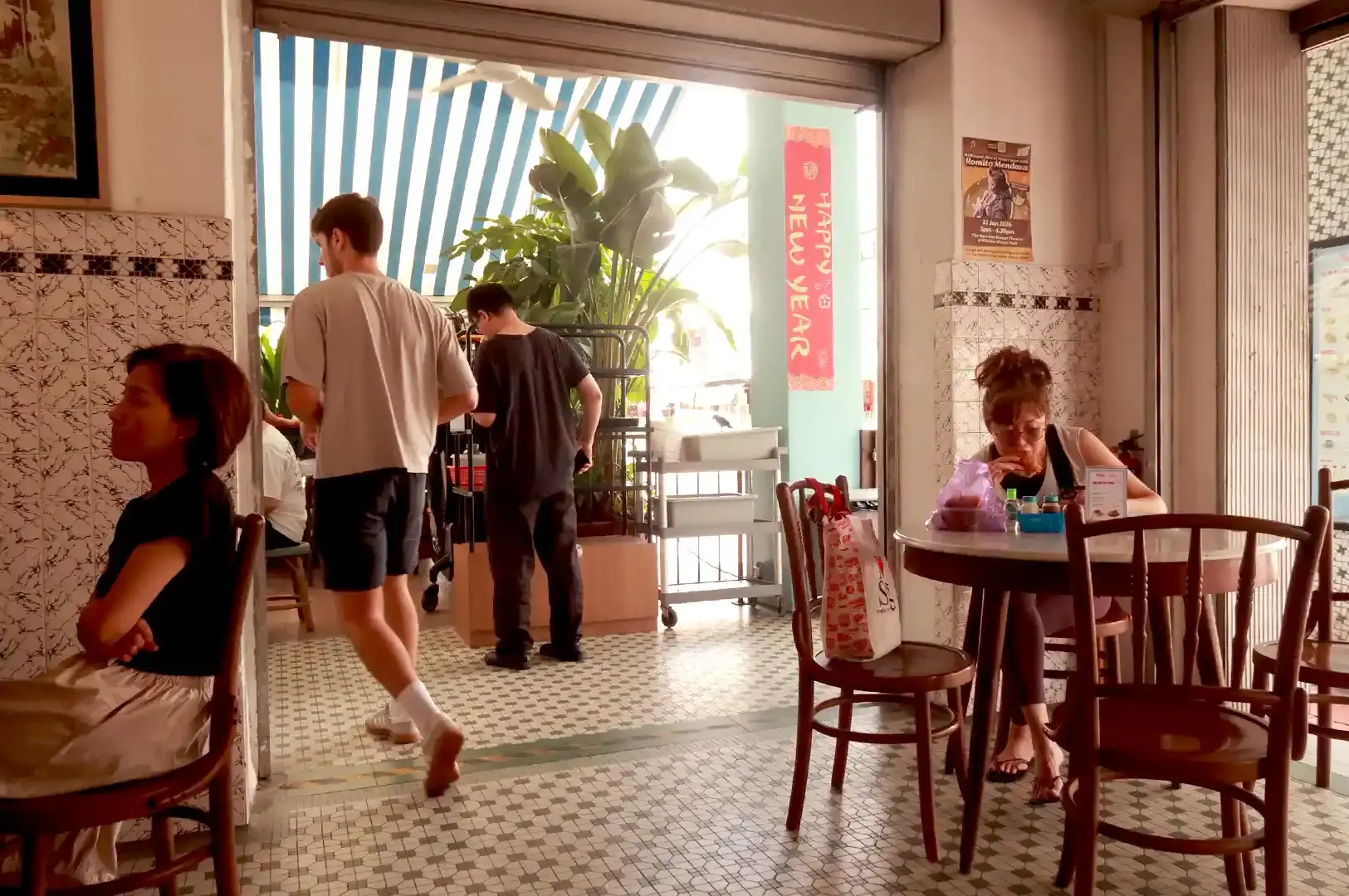 Patrons dining inside a traditional Singapore coffee shop, capturing the nostalgic atmosphere and everyday local coffee scene.