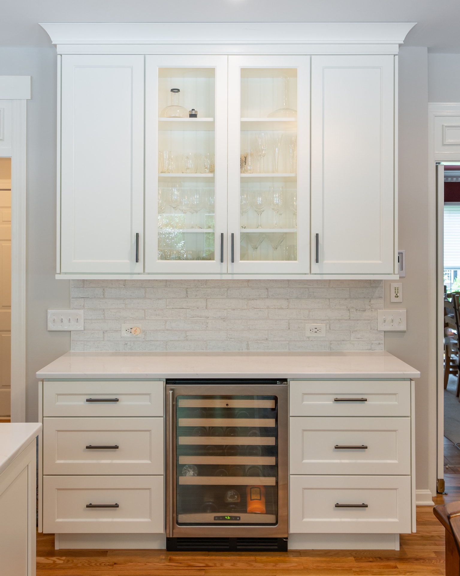 Photo of kitchen cabinets and a countertop with multiple electrical outlets in-between.