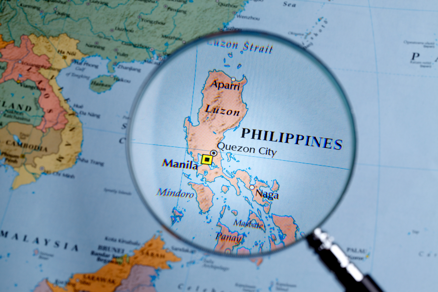 Philippine map with a magnifying glass over it.