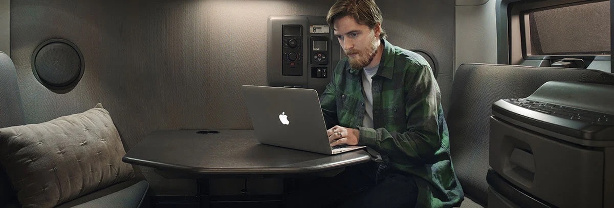 Trucker working on his Mac Laptop in his cab.