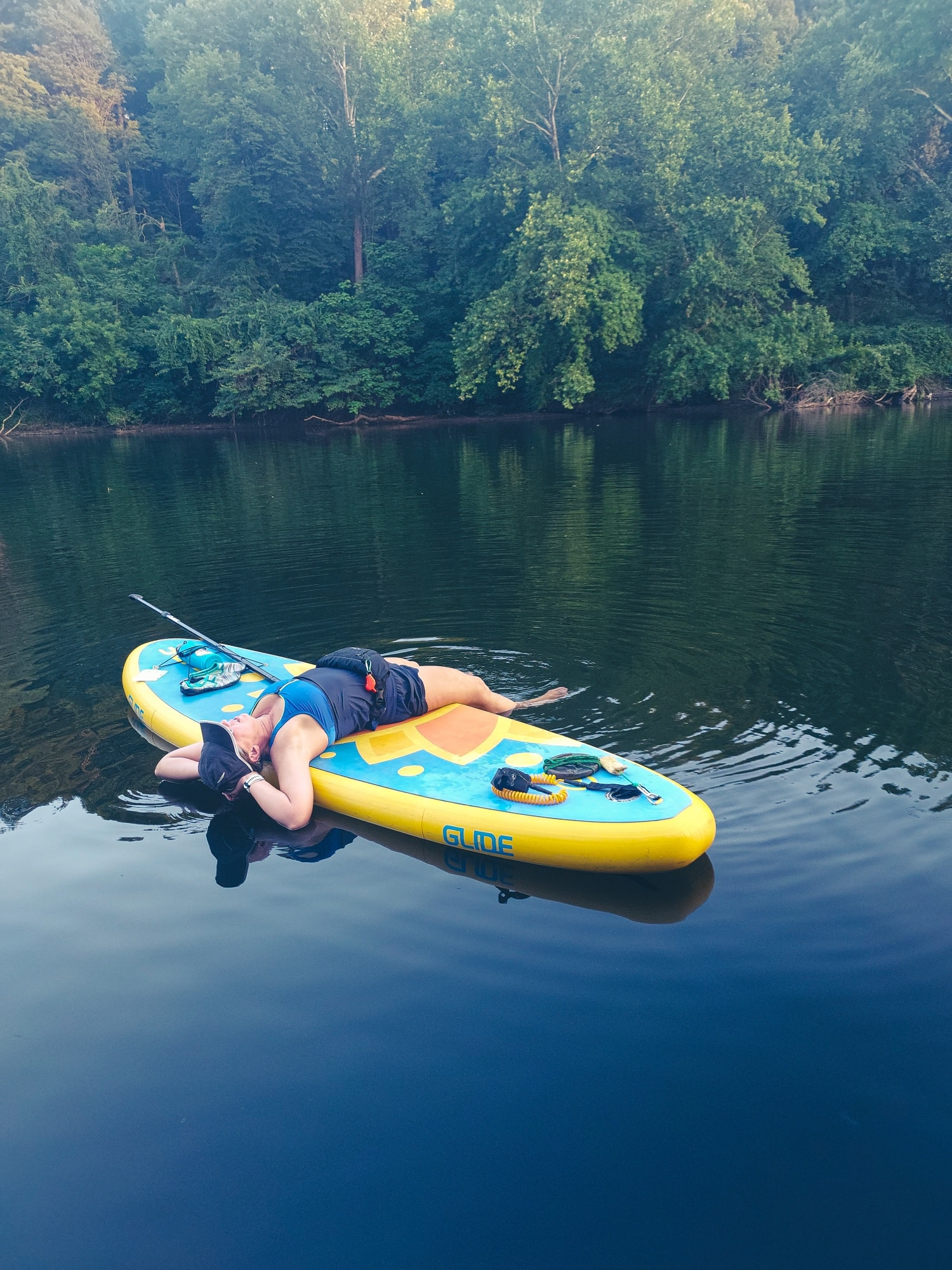 woman lying on an inflatable paddle board